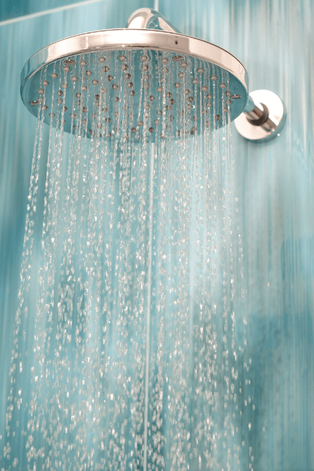 Shower head spraying water with a light blue background