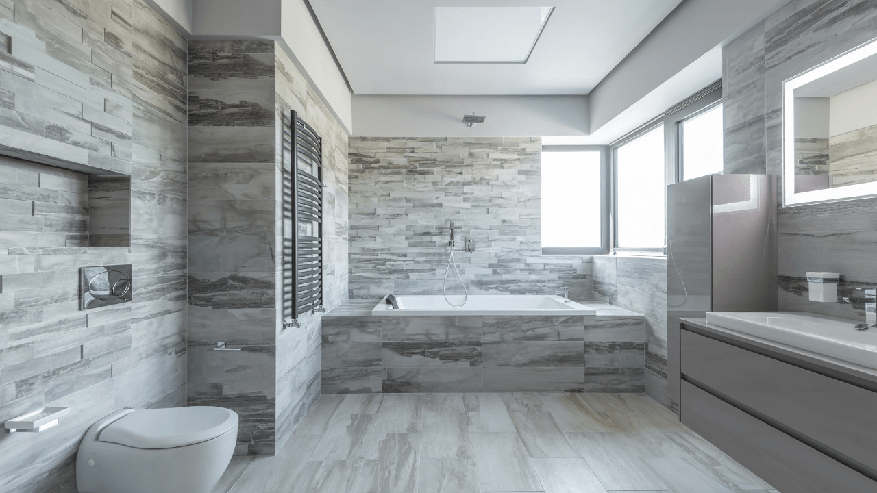 Marble-styled bathroom with large renovated bathtub and long sink